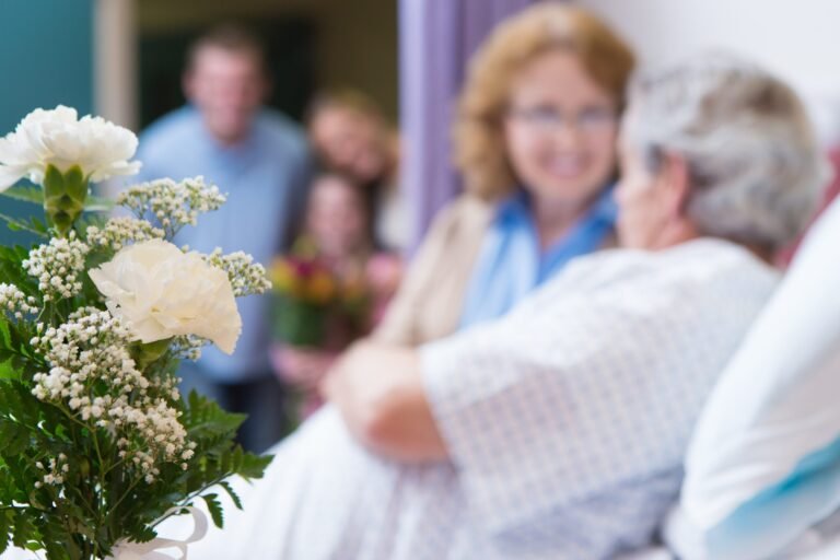 Closeup of flowers in hospital room while family visits grandparents